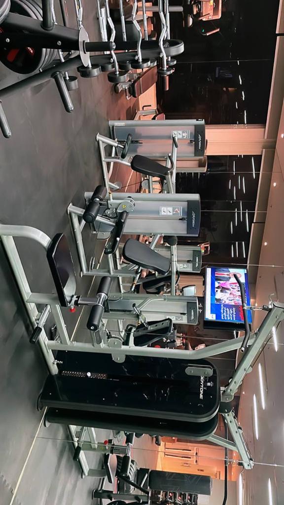 Group of people doing push-ups with dumbbells on floor