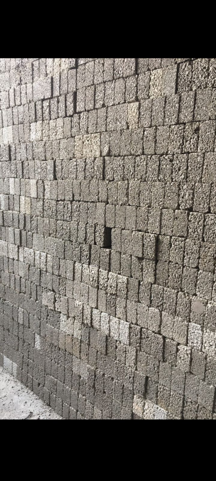 Vista de un almacén industrial con montones de materia prima y estanterías llenas de cajas de cartón.