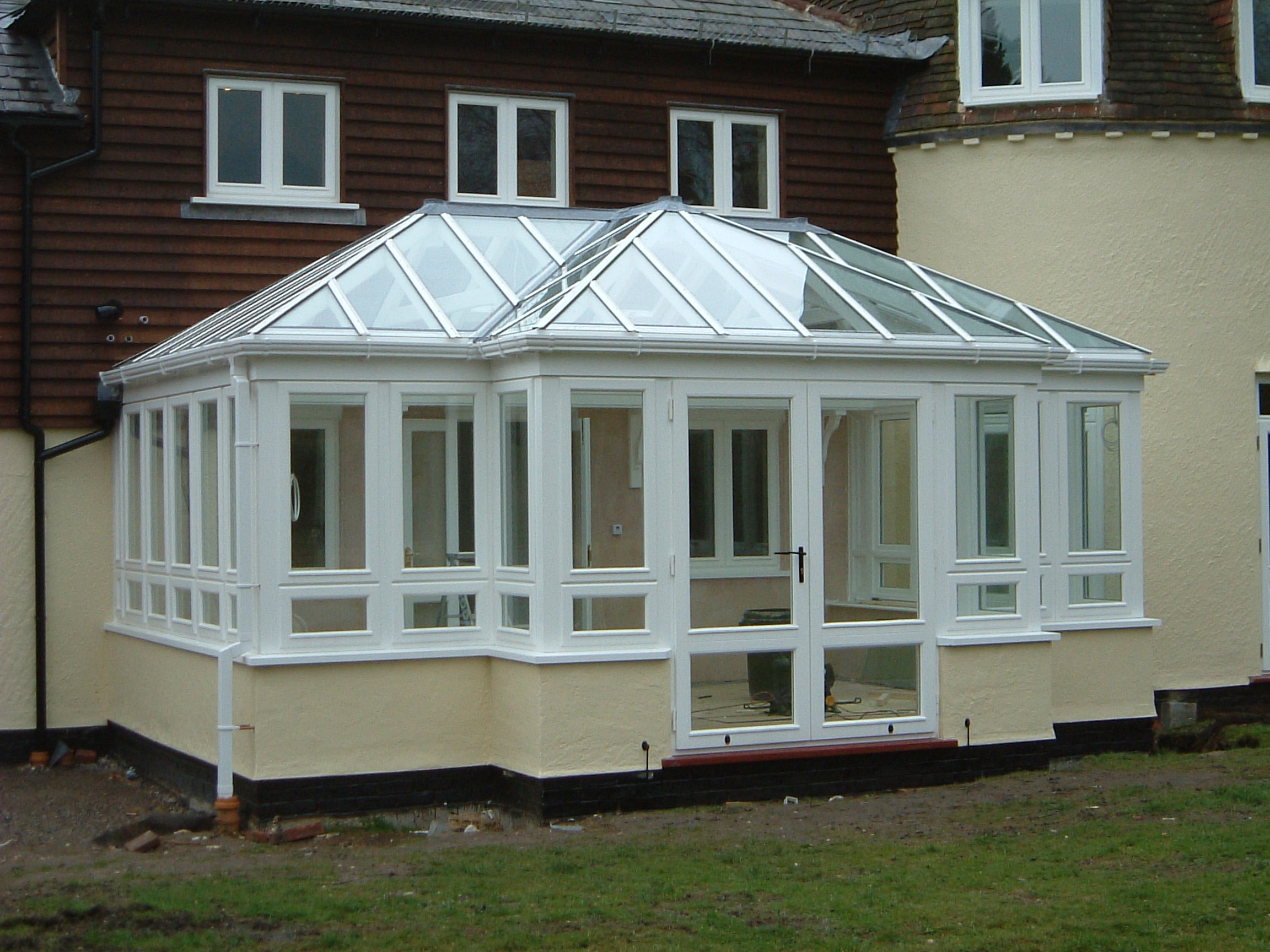 man in black t-shirt and gray pants standing near white wall