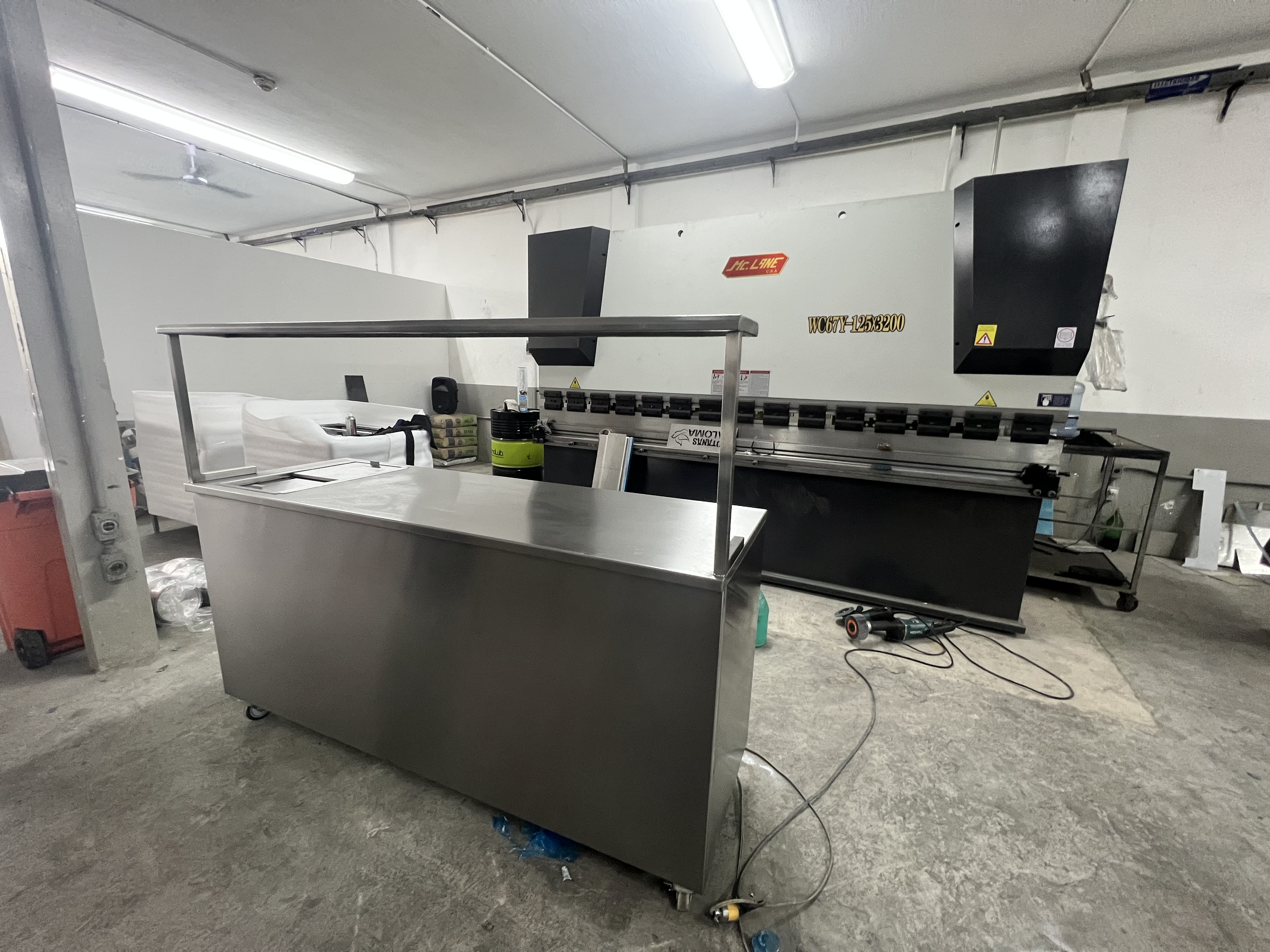 Pasillo de supermercado con refrigeradores llenos de productos iluminados, figura de persona al fondo.