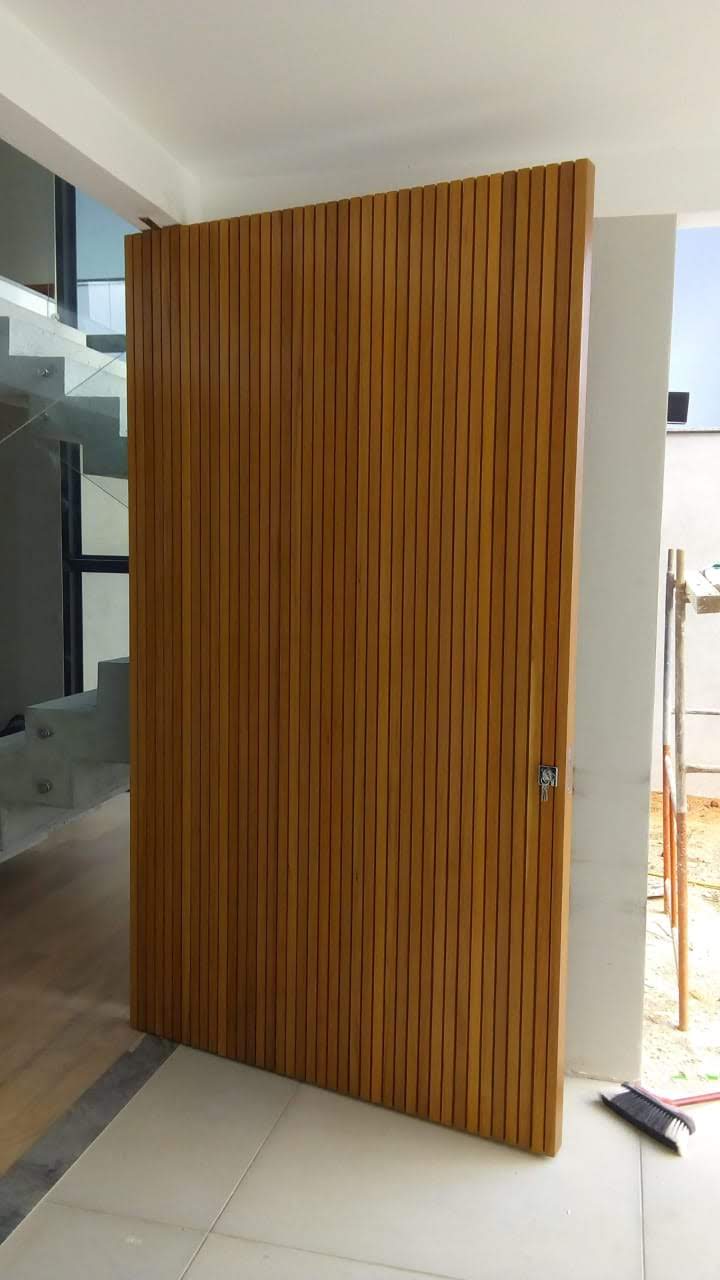 Porta 700 - Porta de madeira ripada e sistema de abertura pivotante.