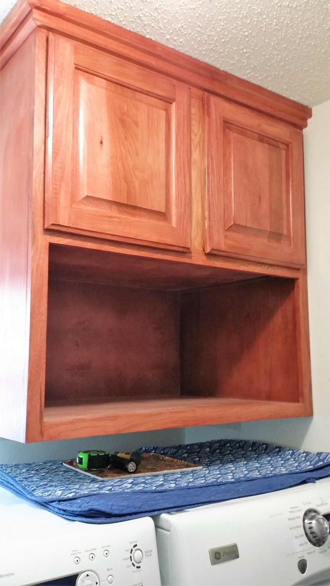 Hickory Utility cabinet features raised
 panel doors with a Sedona red stain. 