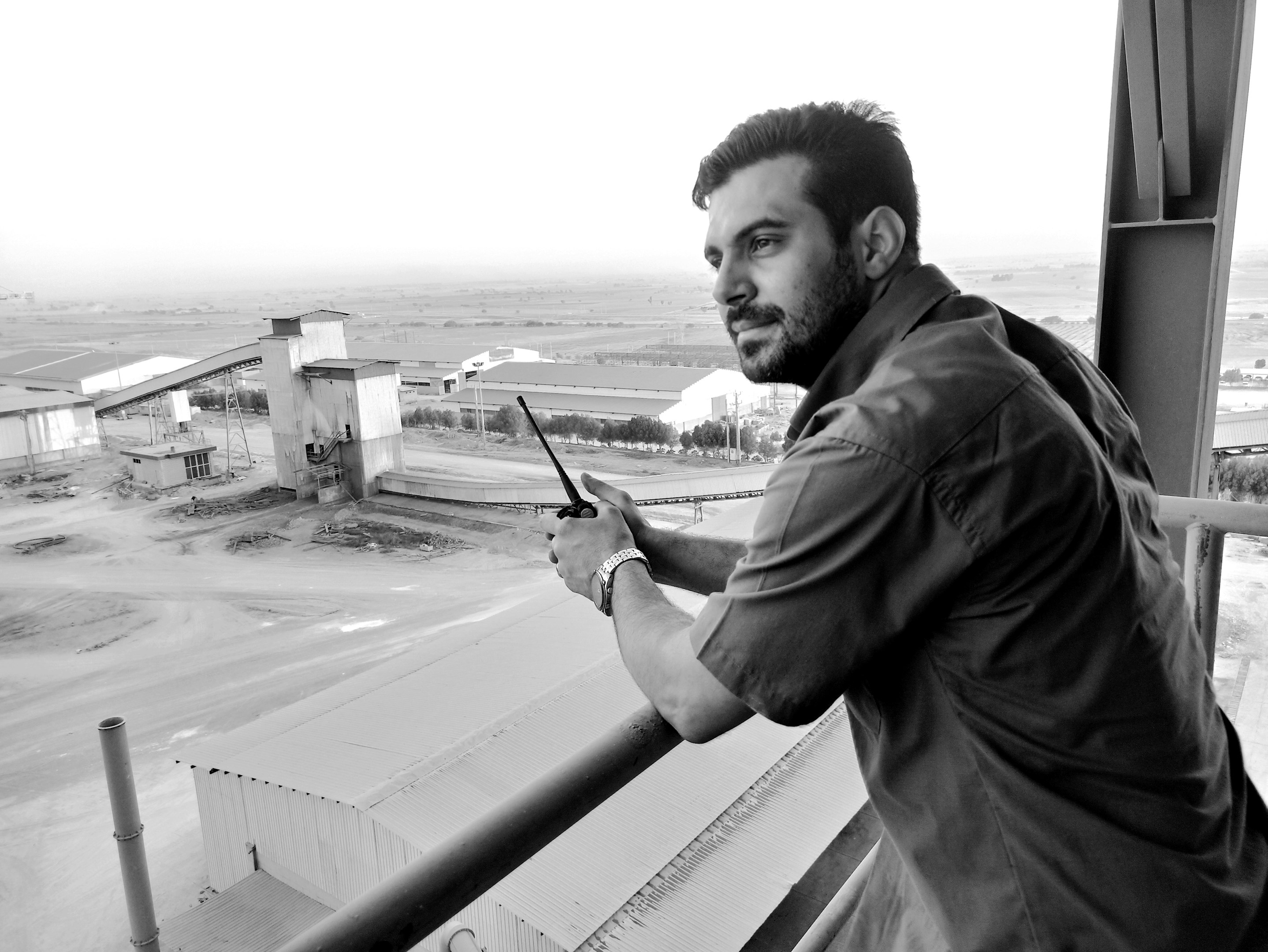 A man standing on a balcony holding a cell phone