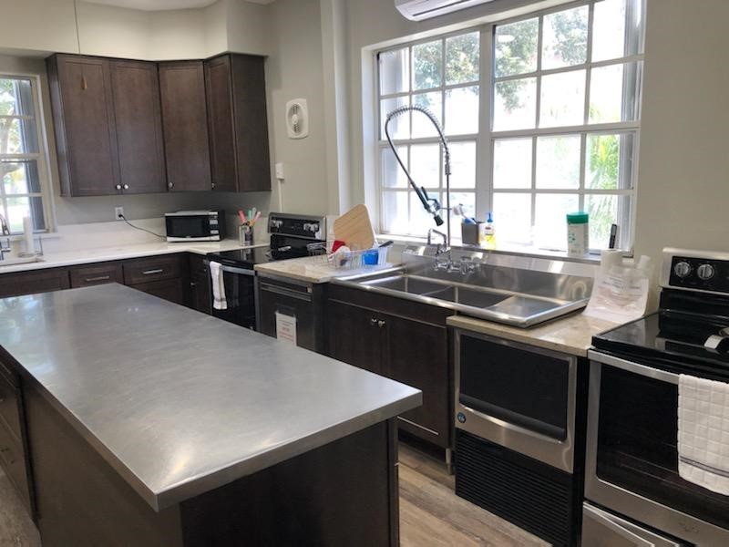 Large kitchen with matching Island featuring an oversize commercial grade sink and double ovens.