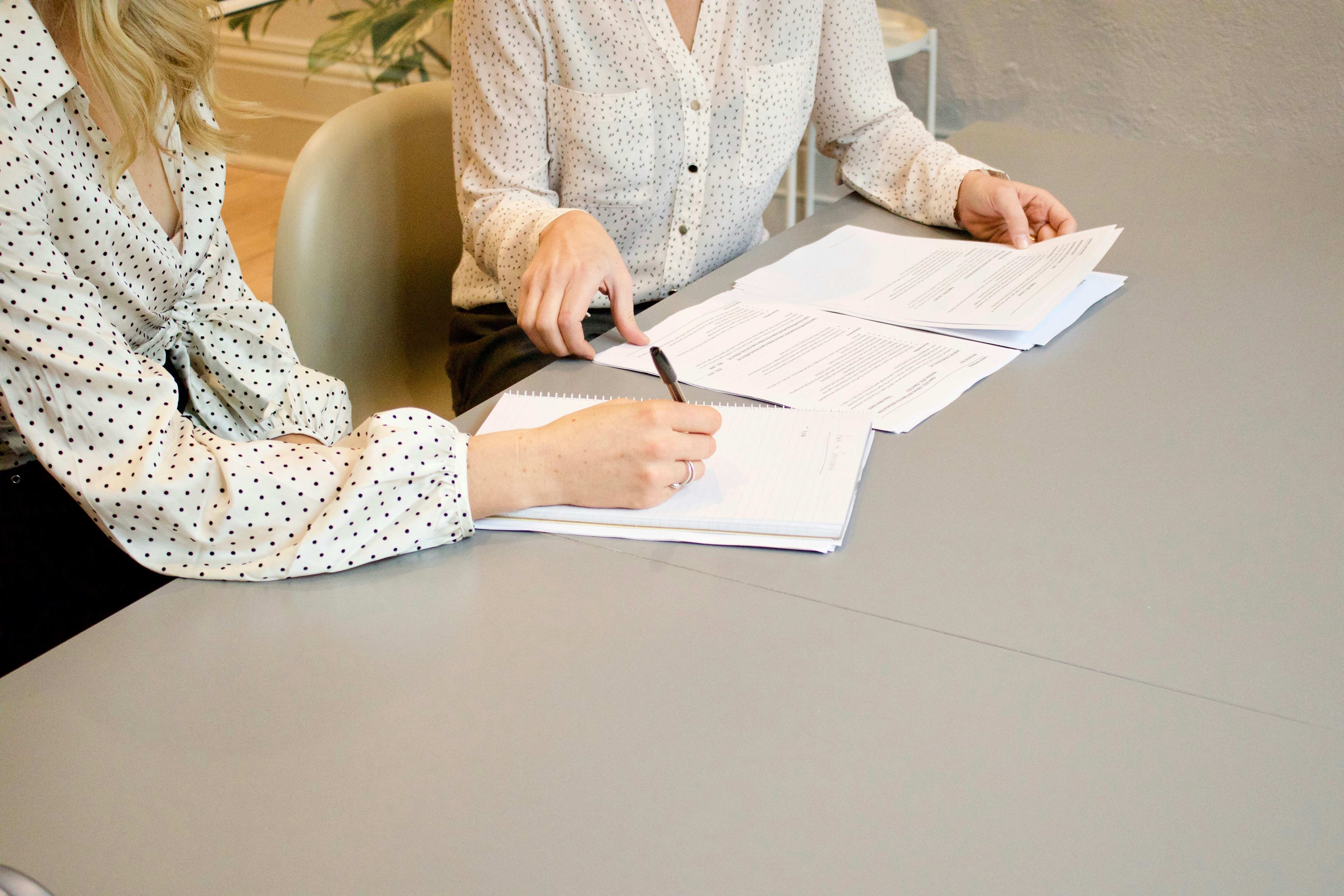 Moderna recepción en una firma de abogados con diseño elegante, mostrador curvo y pantallas digitales.