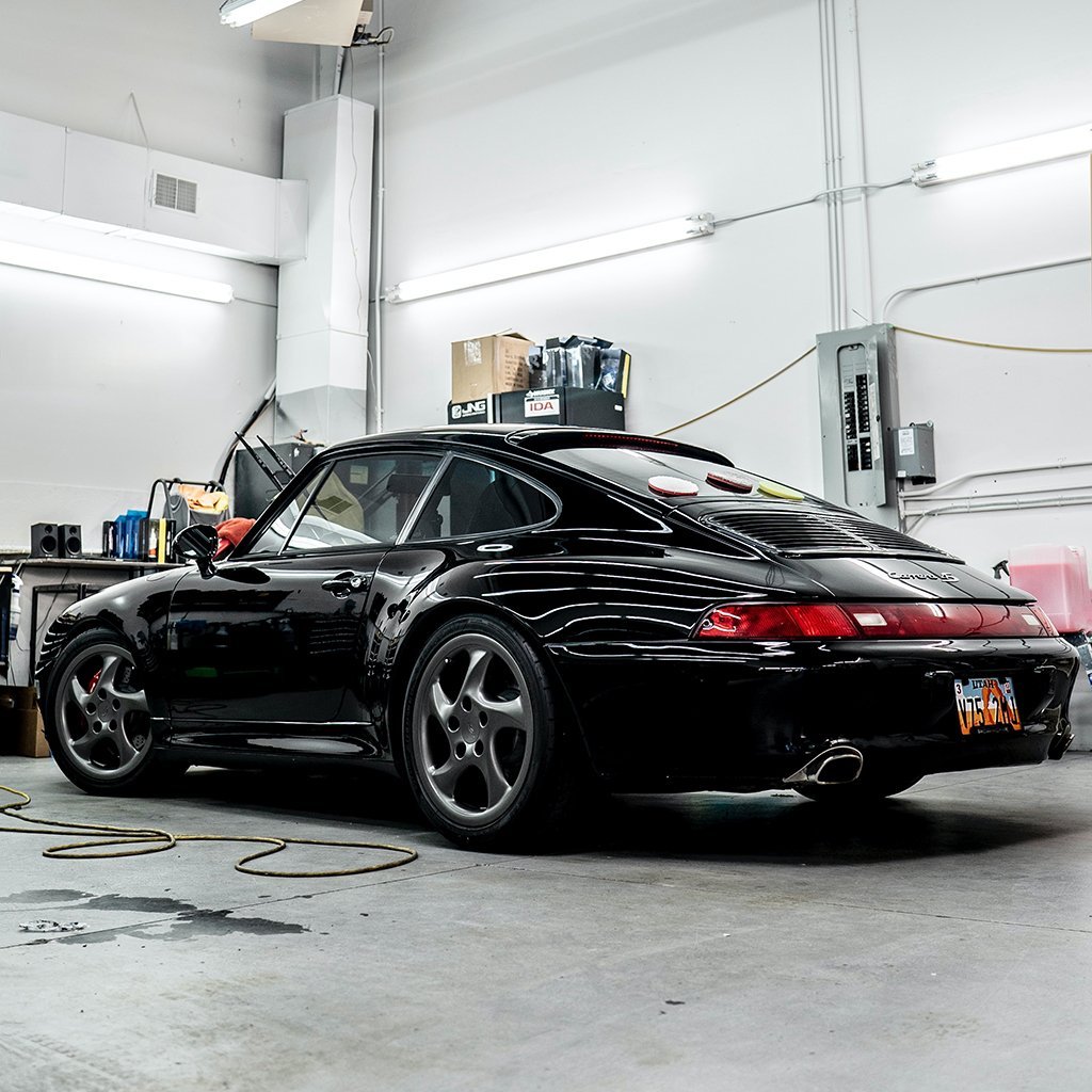 a black Porsche in an automotive garage