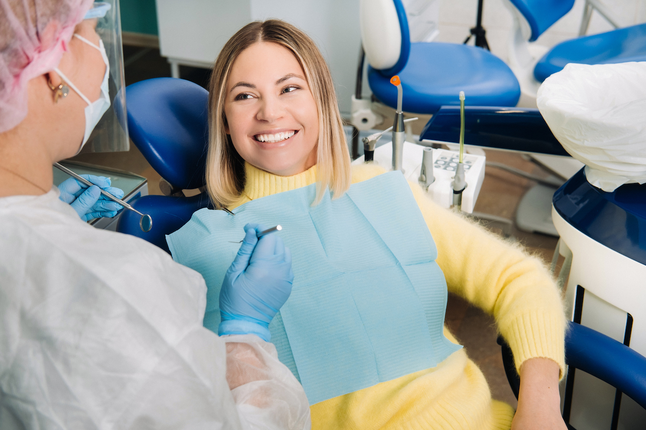 woman sitting in dental chair meeting with dentist