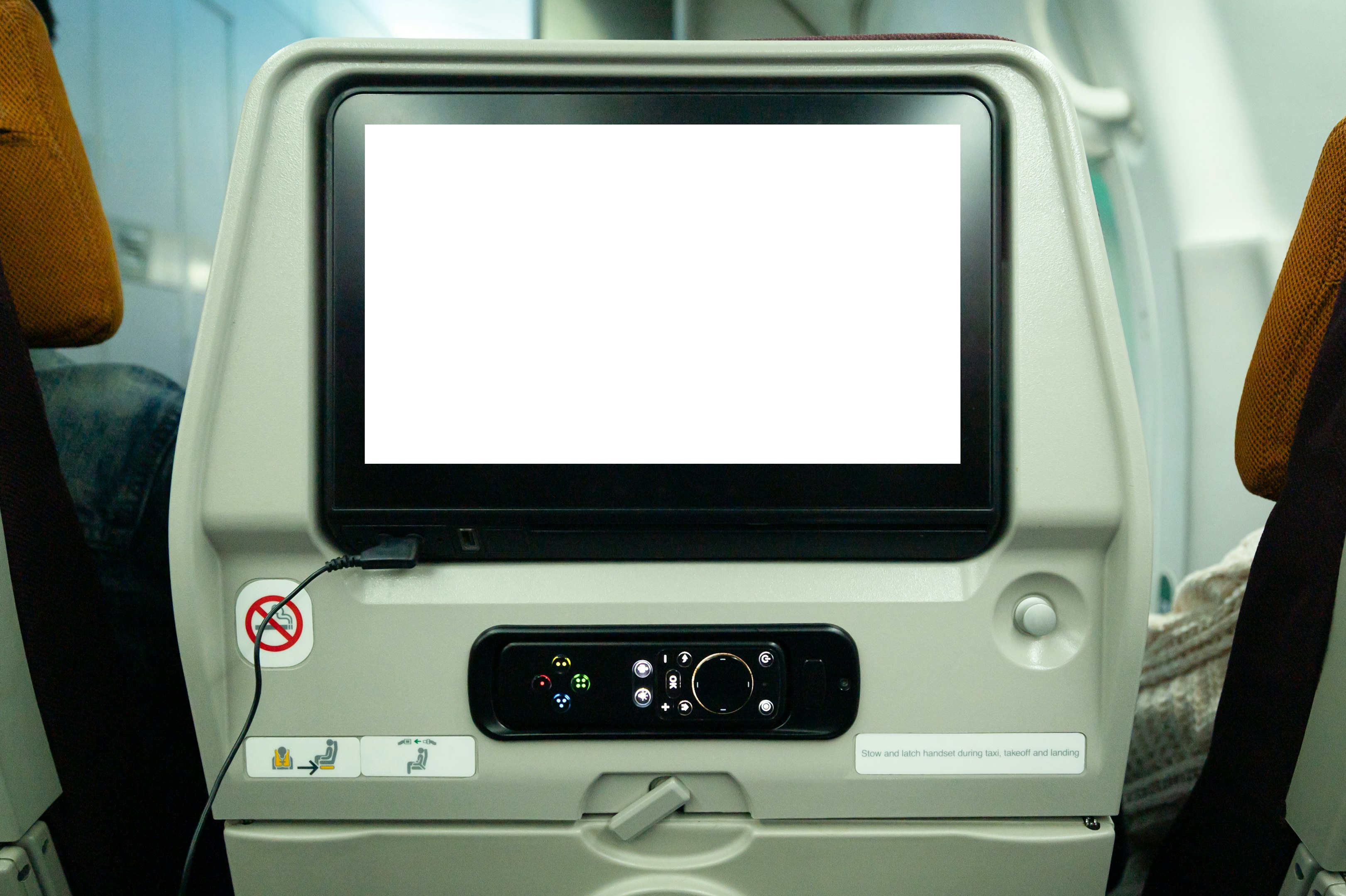 un monitor de computadora sentado encima de un asiento de avión