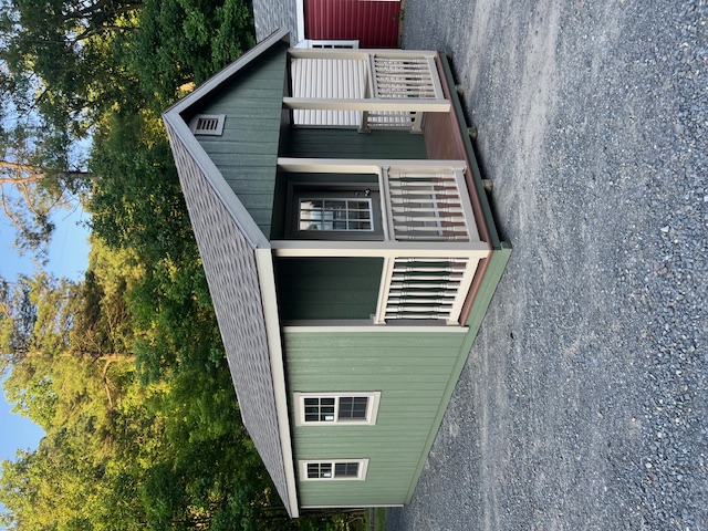 This beautiful 12x24 New England Deluxe Cape Cod Cottage featuring Pequea Green colored wood siding, Clay colored New England trim, and it also featured the Driftwood colored architectural shingles with synthetic underlayment.  This structure was also equipped with classic gable ventilation, 5 30"x36" double hung insulated house windows, 1 3'x75" 9 lite fiberglass house door, a 4x12 porch with composite decking along with vinyl railing, pressure treated floor joists, and skids.