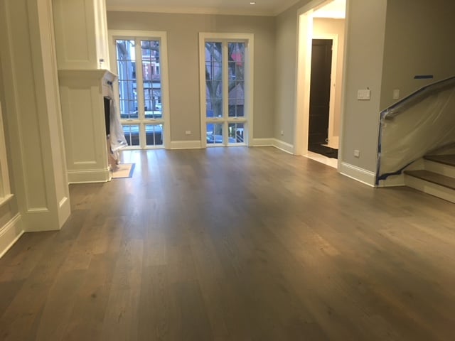 hardwood floor repair and restorations in room with large windows
