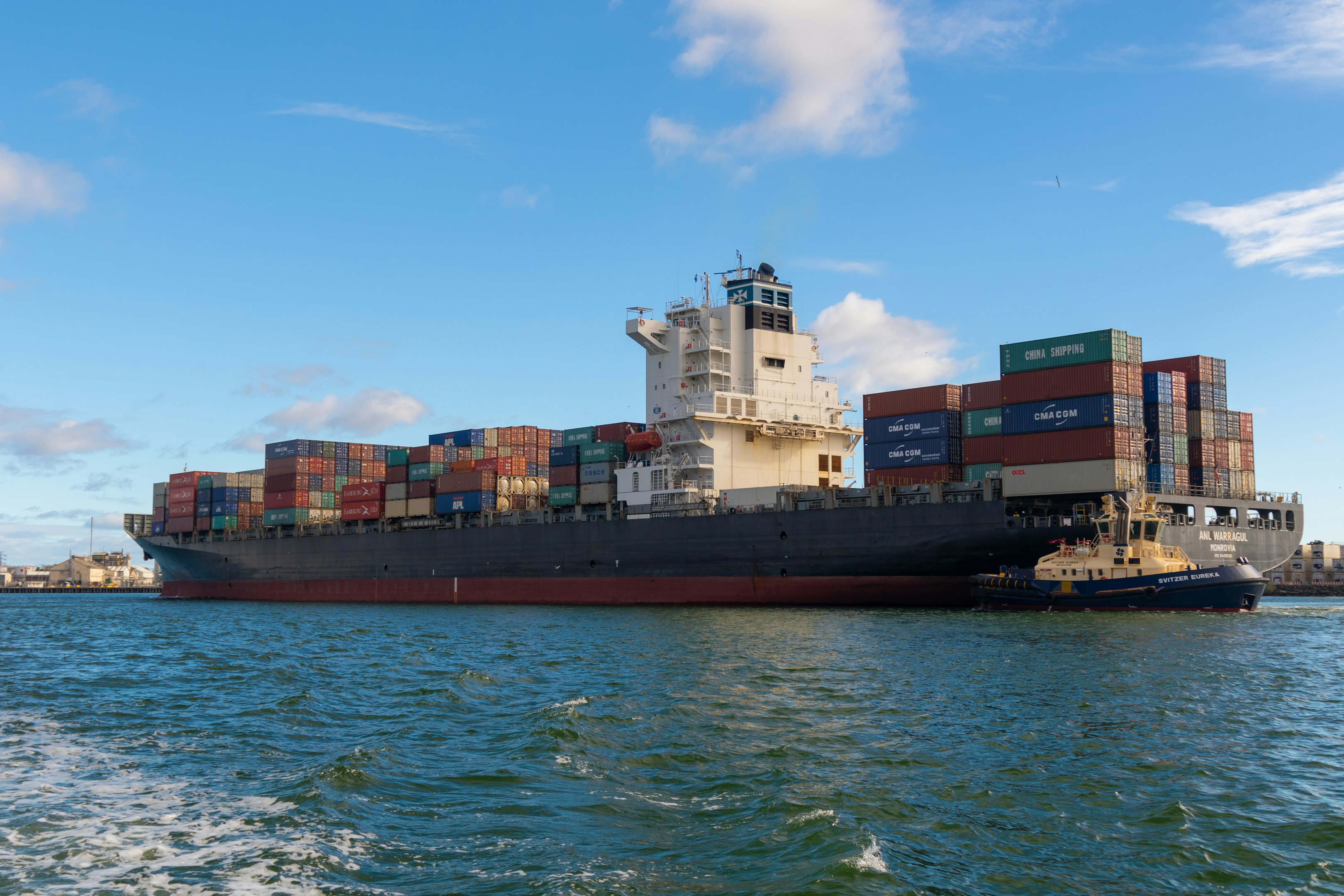barco de carga negro en el mar bajo el cielo azul durante el día