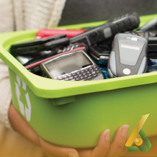 Persona sosteniendo contenedor verde de reciclaje lleno de teléfonos móviles antiguos.