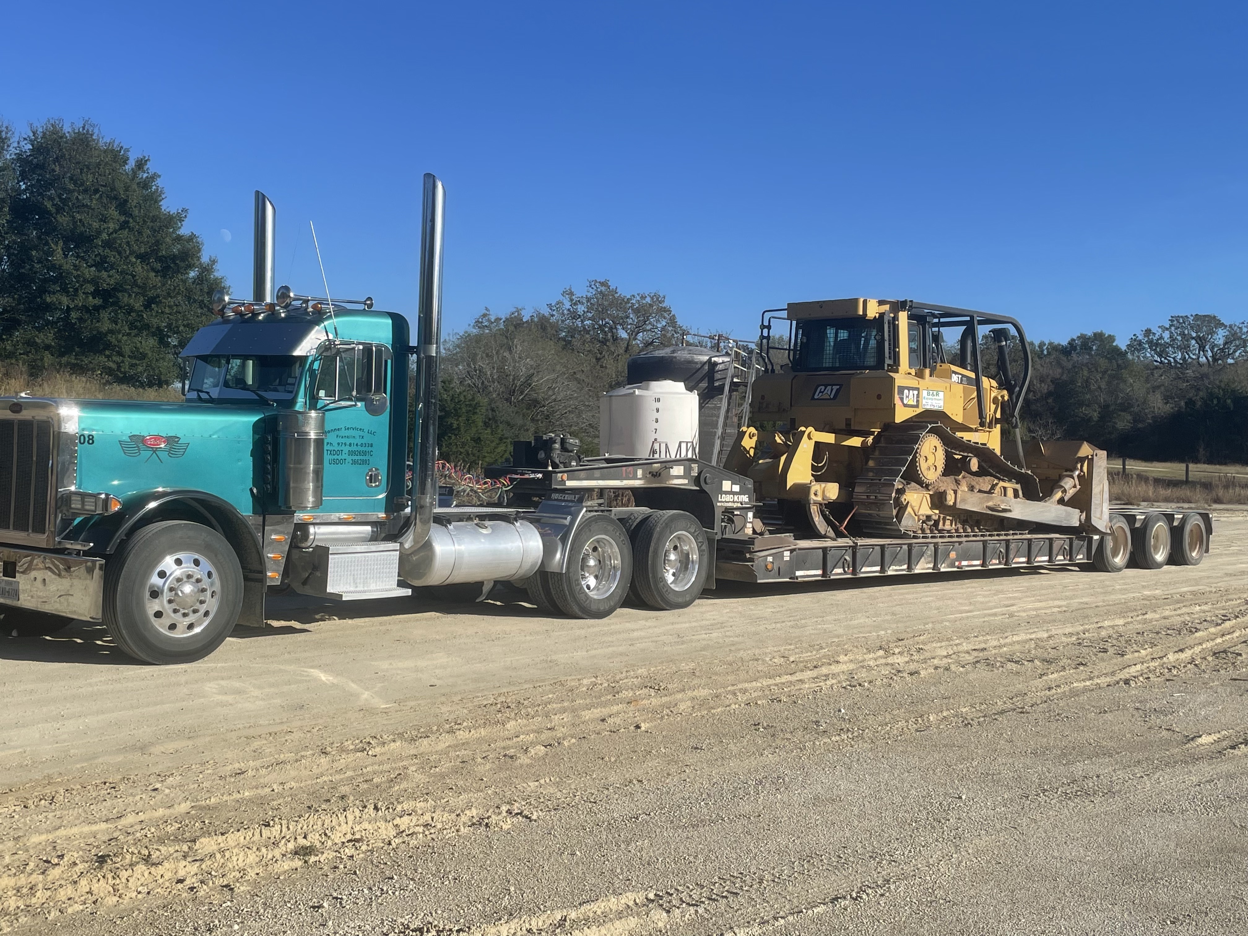Person in orange protective gear welding metal in a factory workshop.