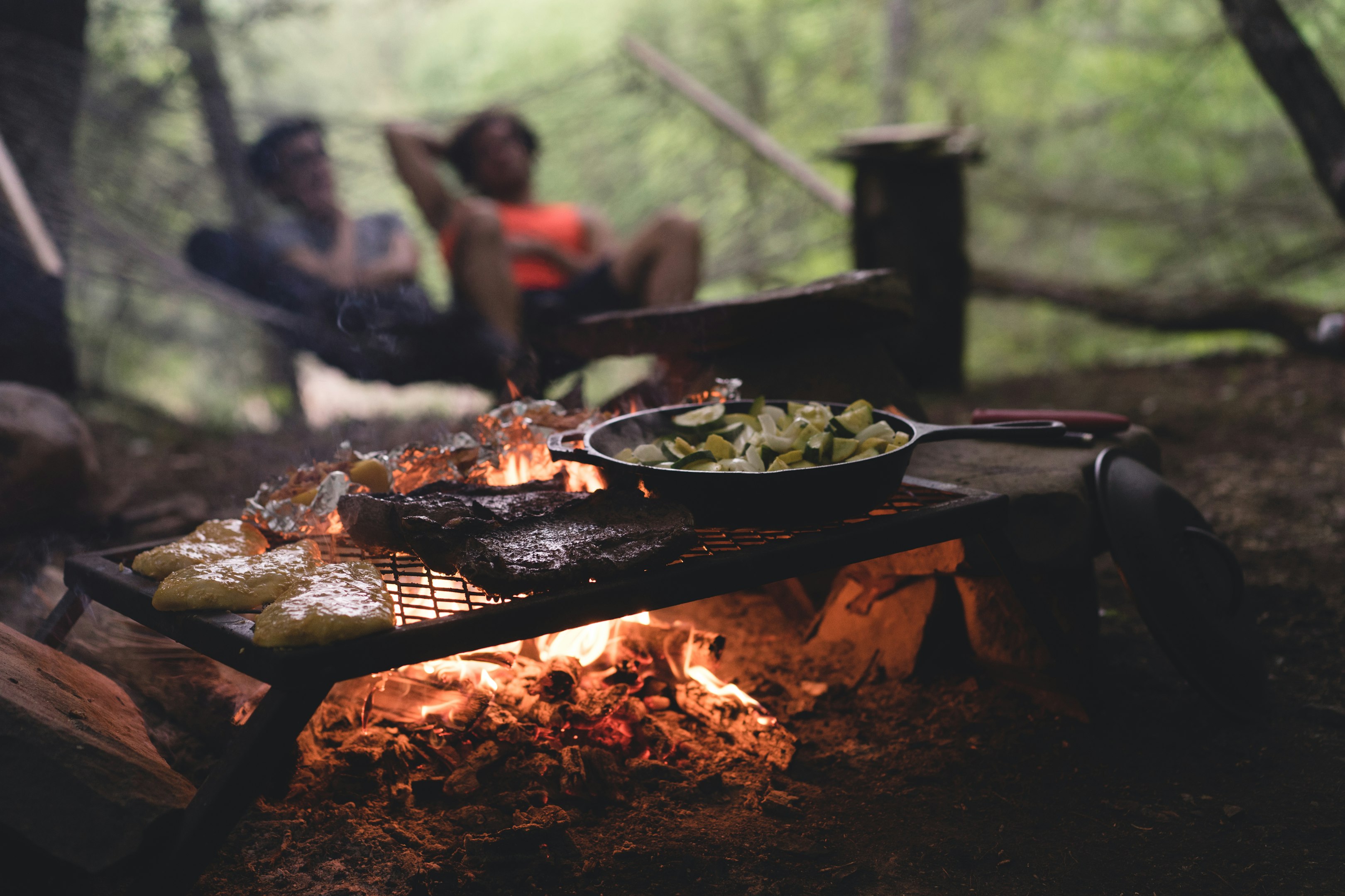 foto con enfoque selectivo de sartén y carne en la parte superior de la parrilla con fuego