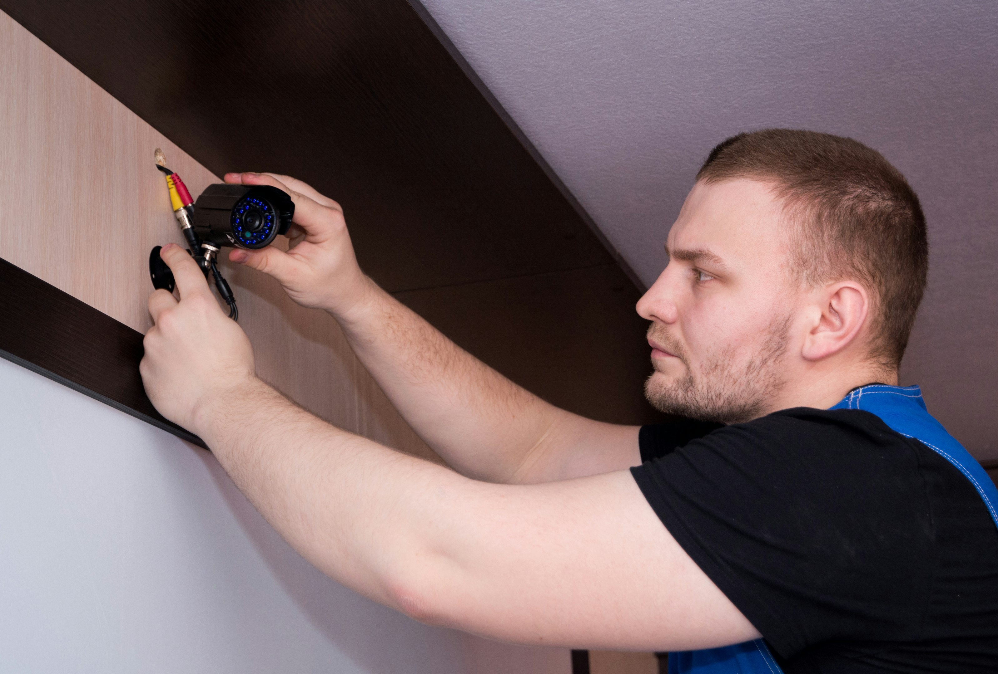un hombre trabajando en una pared con un destornillador