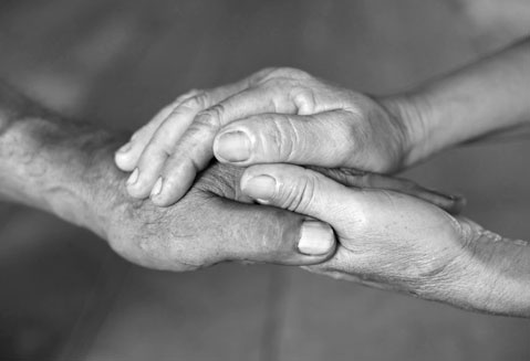 Hand of an Elderly Woman Holding the Hand of an Elderly Man