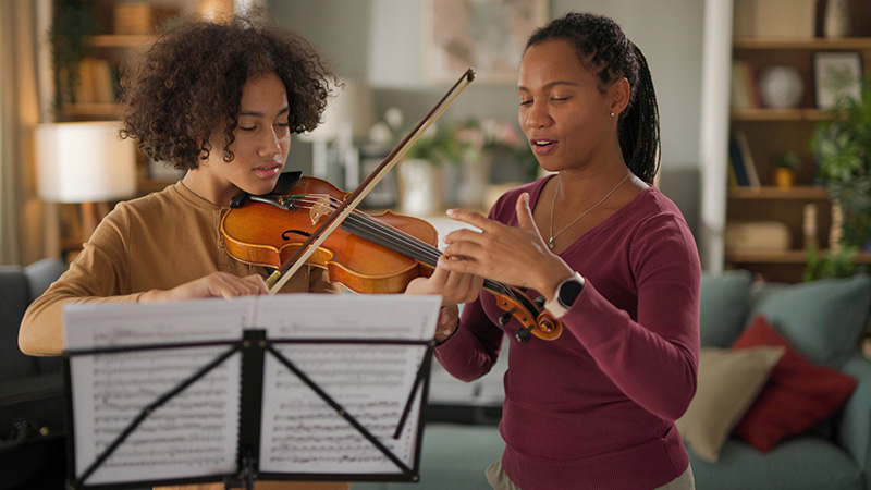 Boy practicing violin at home
