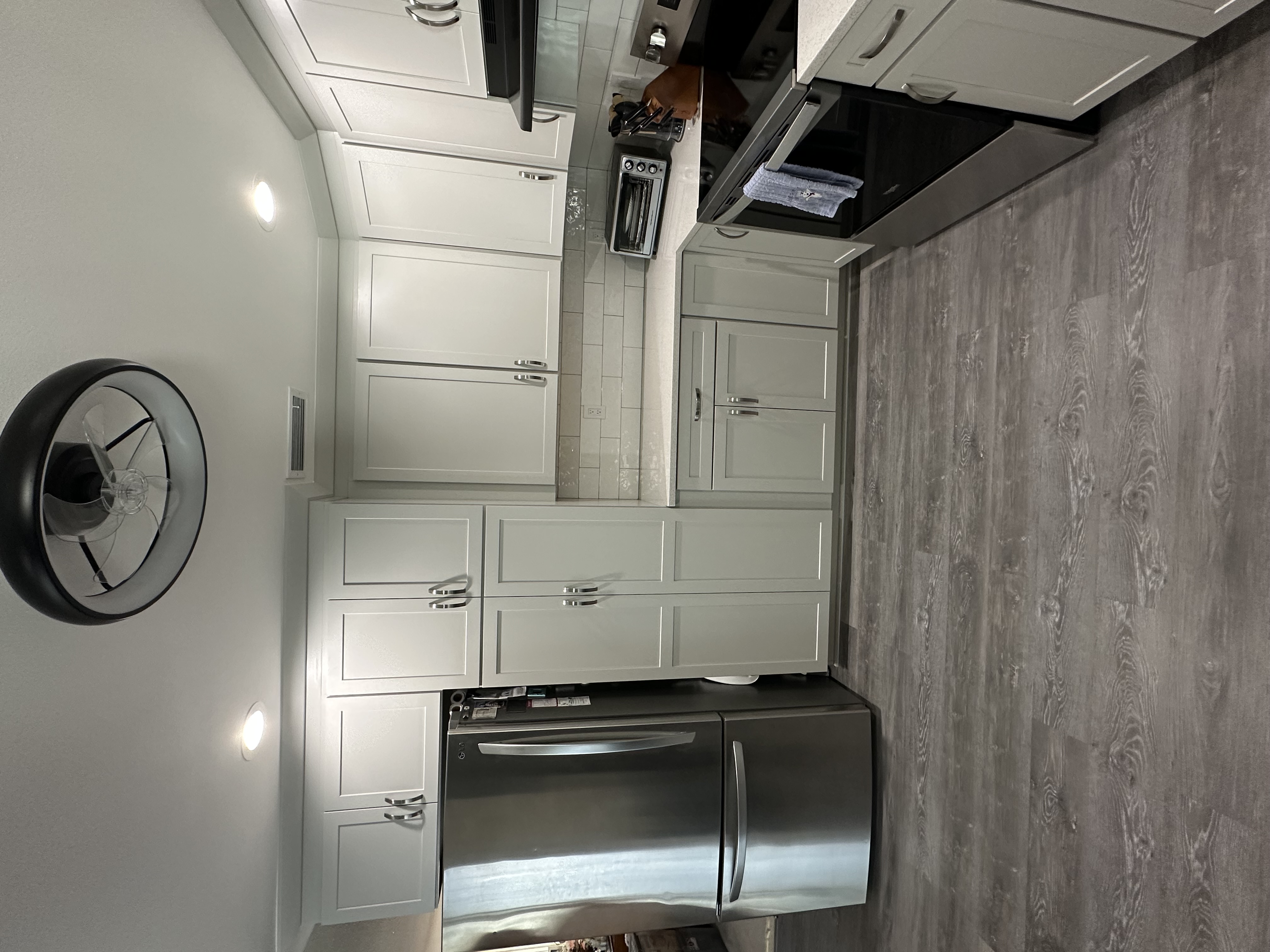 This inviting kitchen features semi-custom cabinetry painted in Icy Avalanche, sparkling white quartz countertops, and elegant satin nickel hardware.