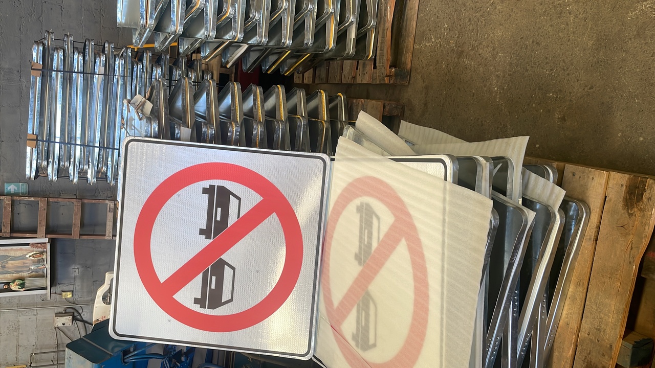 Calle urbana con señal de prohibido el paso a vehículos y señal de cruce peatonal, edificios modernos de fondo.
