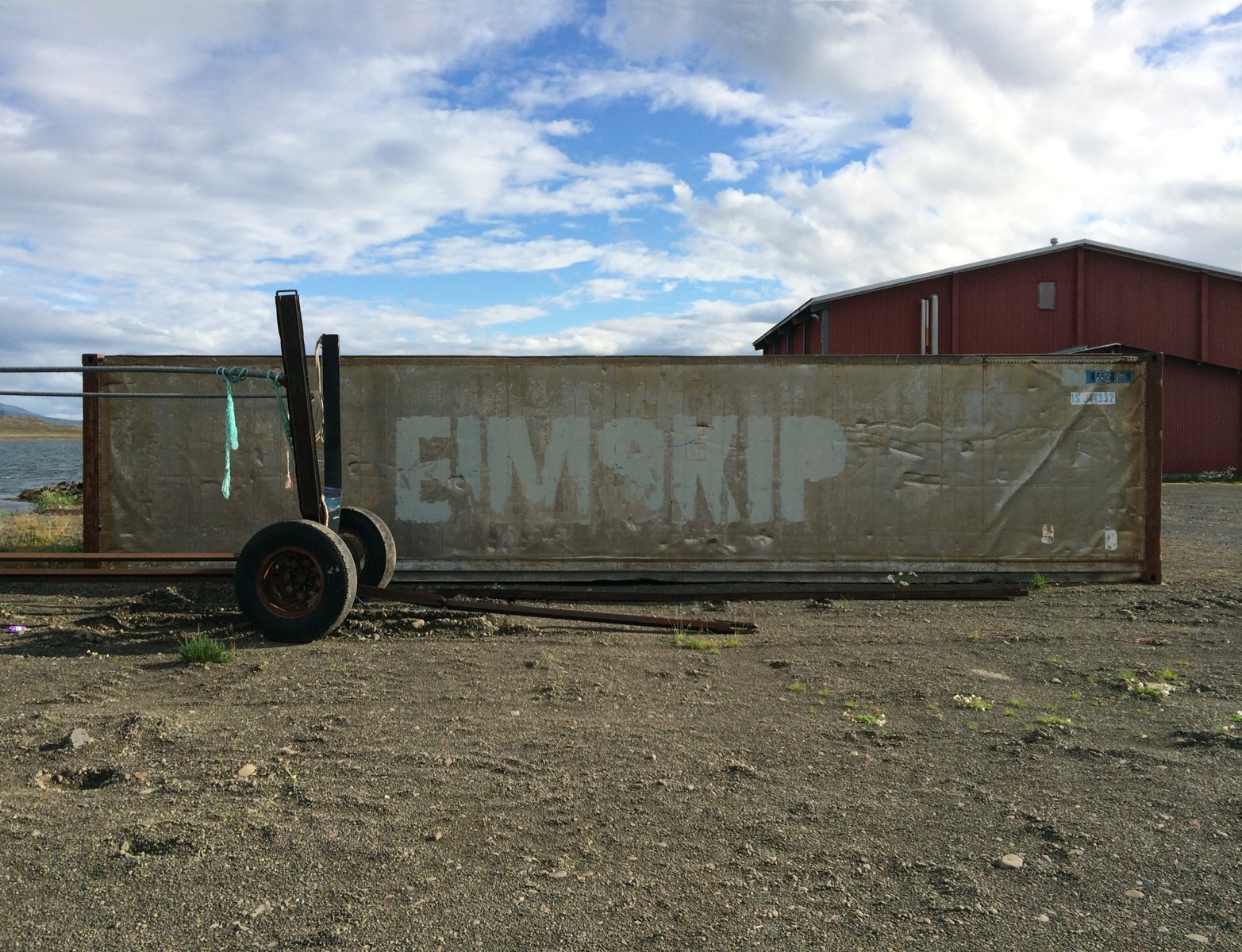 A silver-colored aluminum shipping container with “Eimskip” painted on the side.