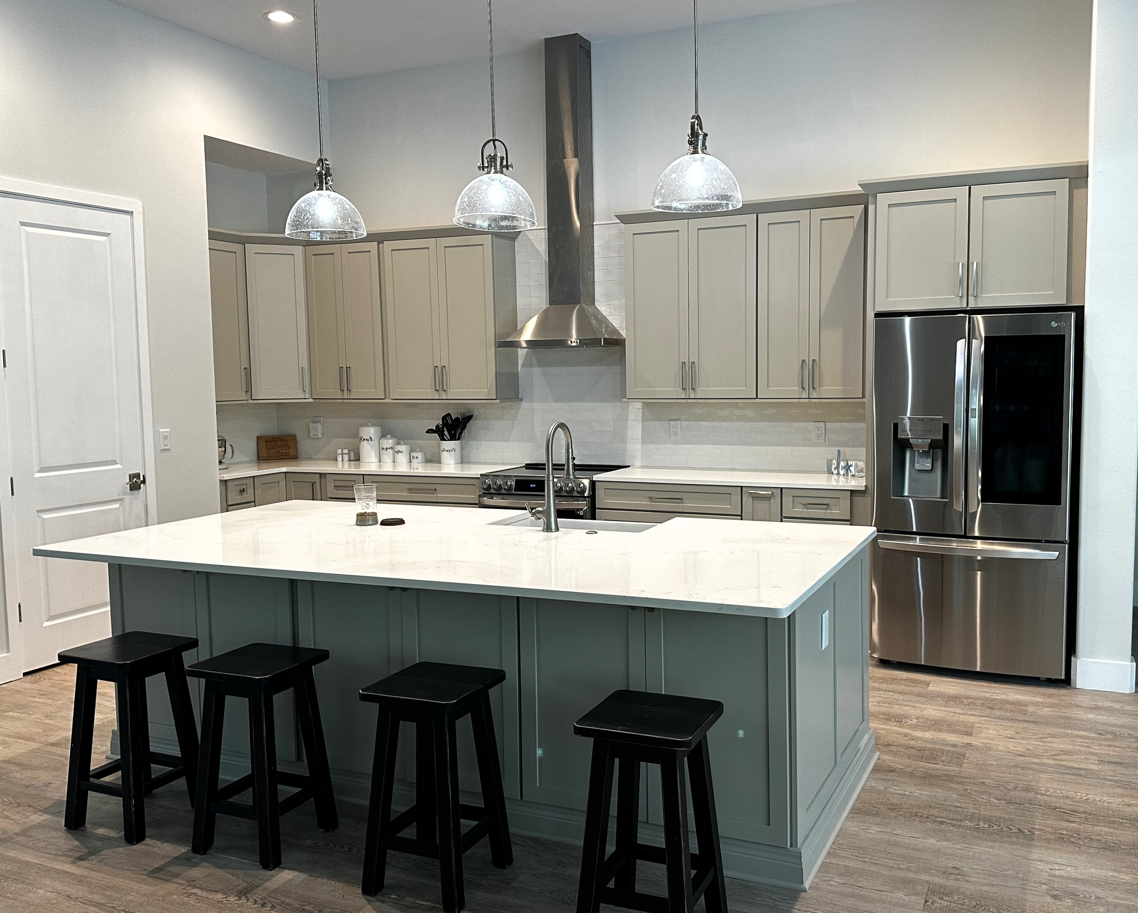 Lovely kitchen with large island featuring beautiful quartz countertops and semi-custom painted cabinetry. 