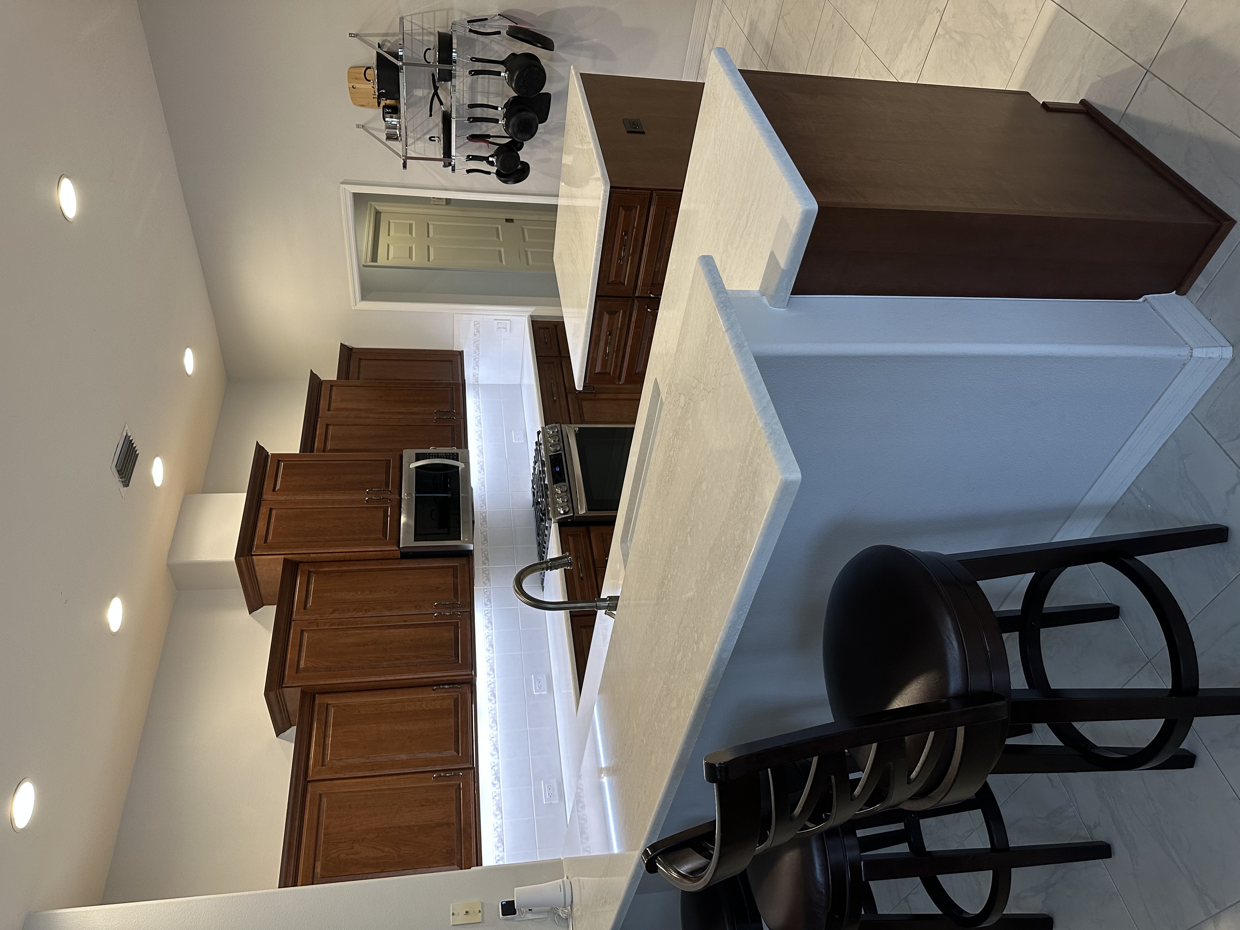 Inviting, versatile kitchen featuring a high bar area with seating and a perfectly sized central island, ideal for meal prep and entertaining.