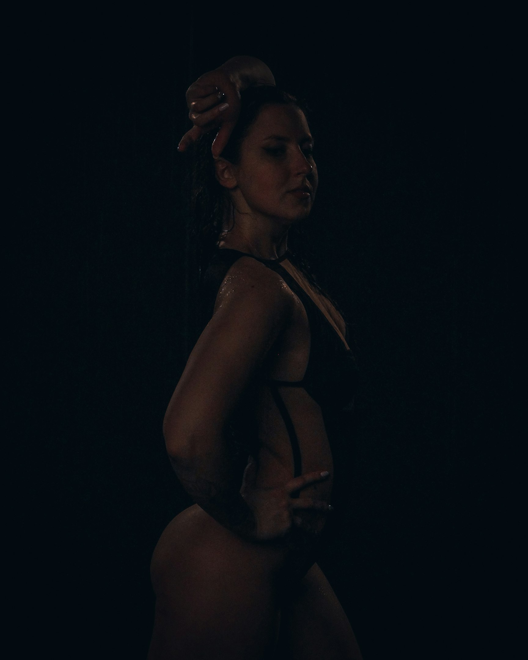 una mujer en traje de baño de pie en la oscuridad