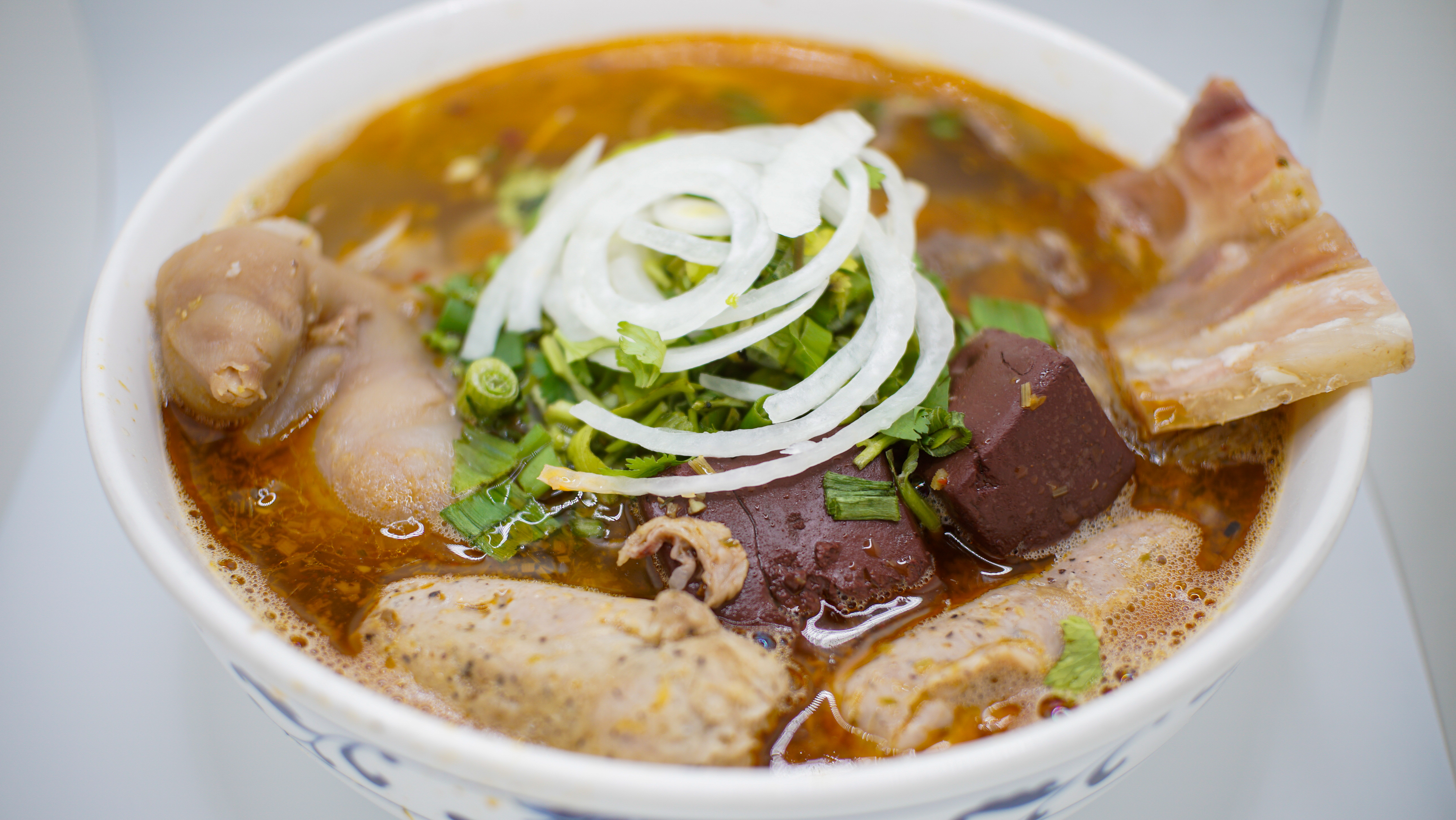 1S.(A) BUN BO HUE
Hot and Spicy Beef & Pork Soup
W/ Beef, Cubes of Congealed
Pig's Blood and Pork Knuckles
And Thick Vermicelli Noodles