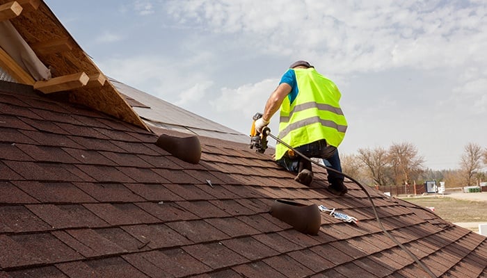 Construction Worker Putting The Asphalt Roofing