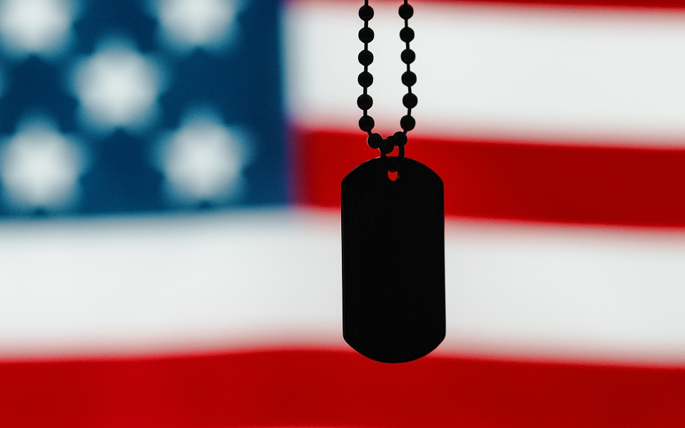 Dog tag with an American flag behind it