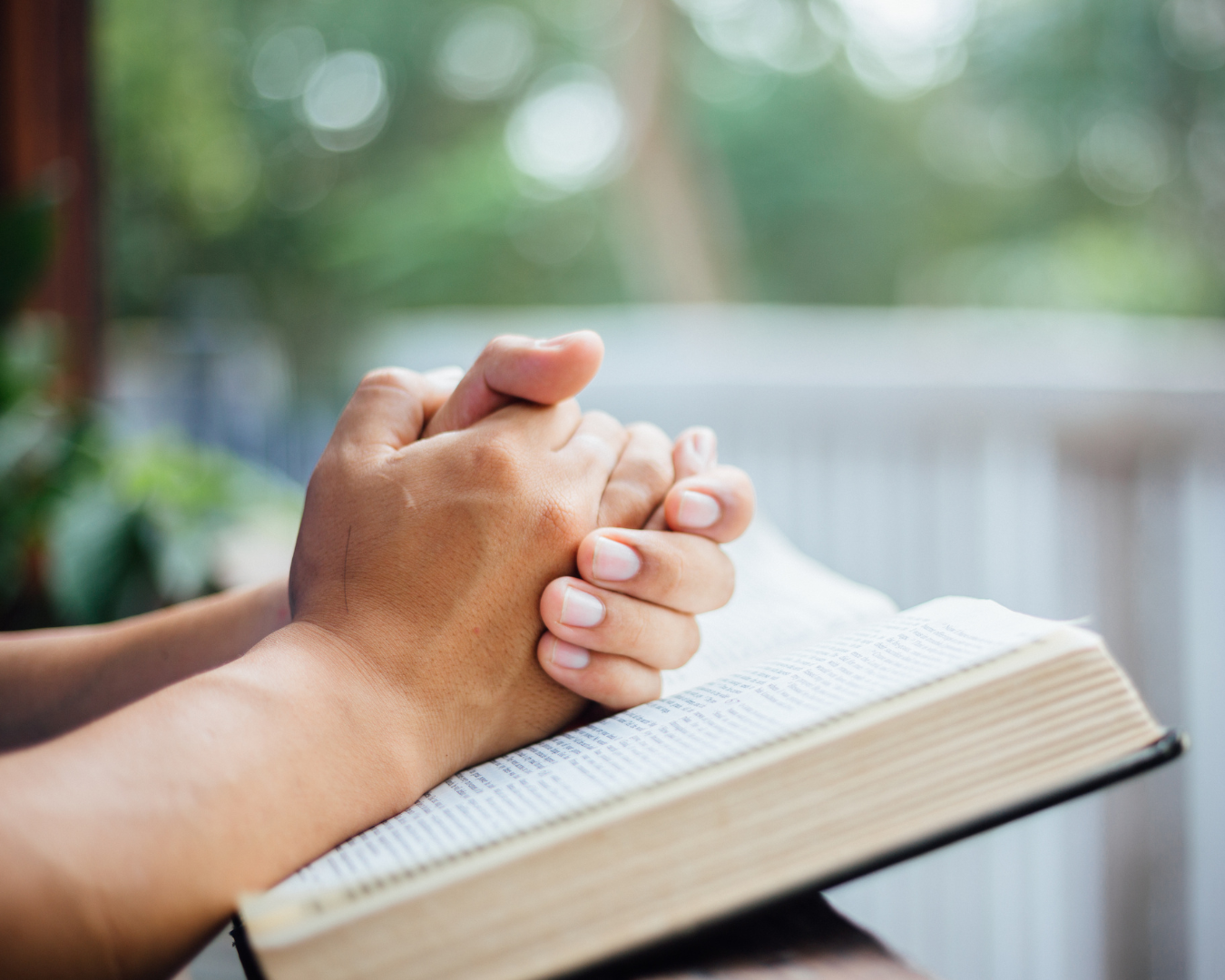 Prayer hands over a Bible