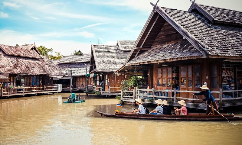 Boat floating on water between homes