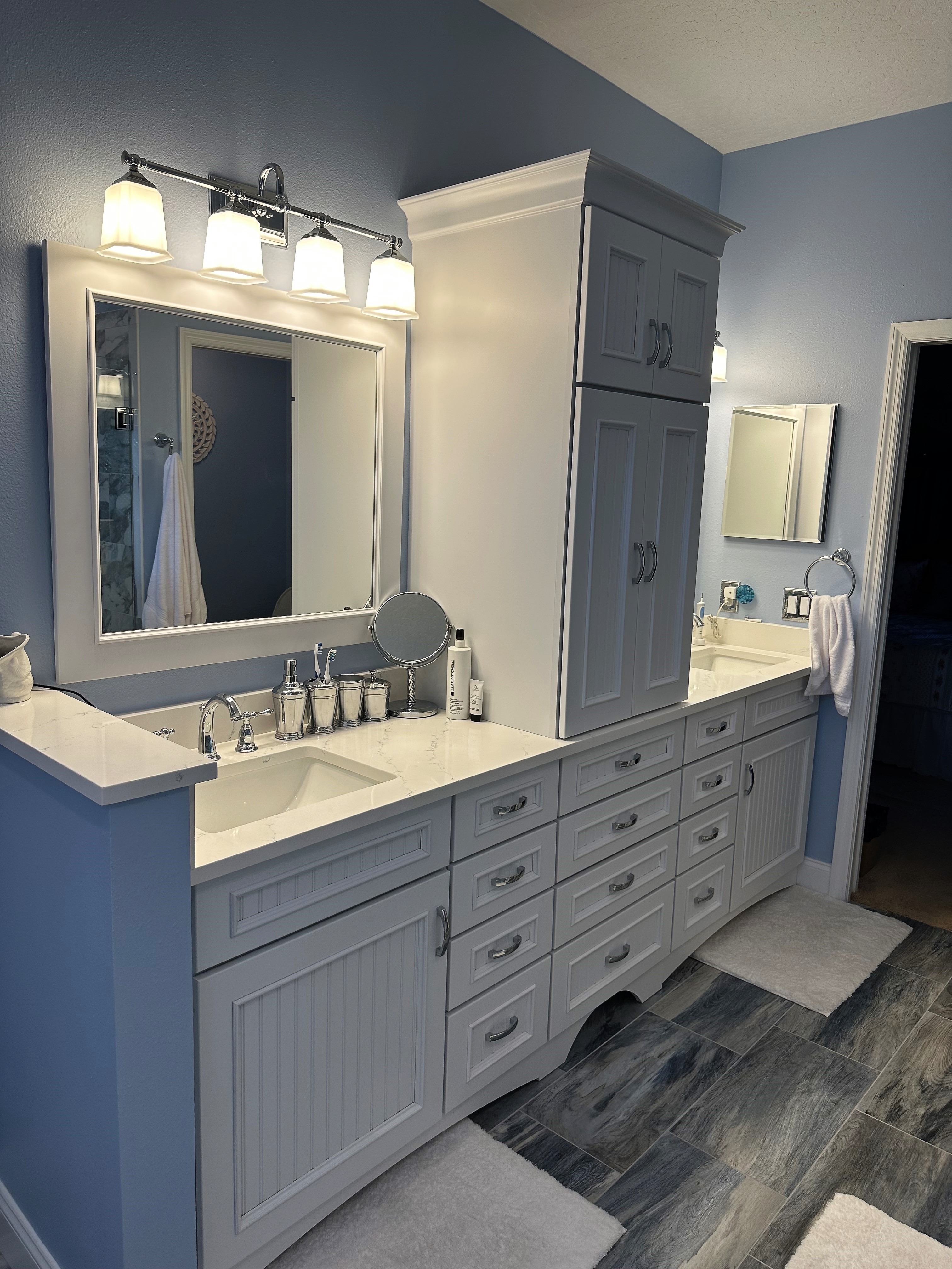 Beautiful maple bead board vanity painted Magnolia featuring double sinks and HanStone Tranquility quartz with chrome hardware.