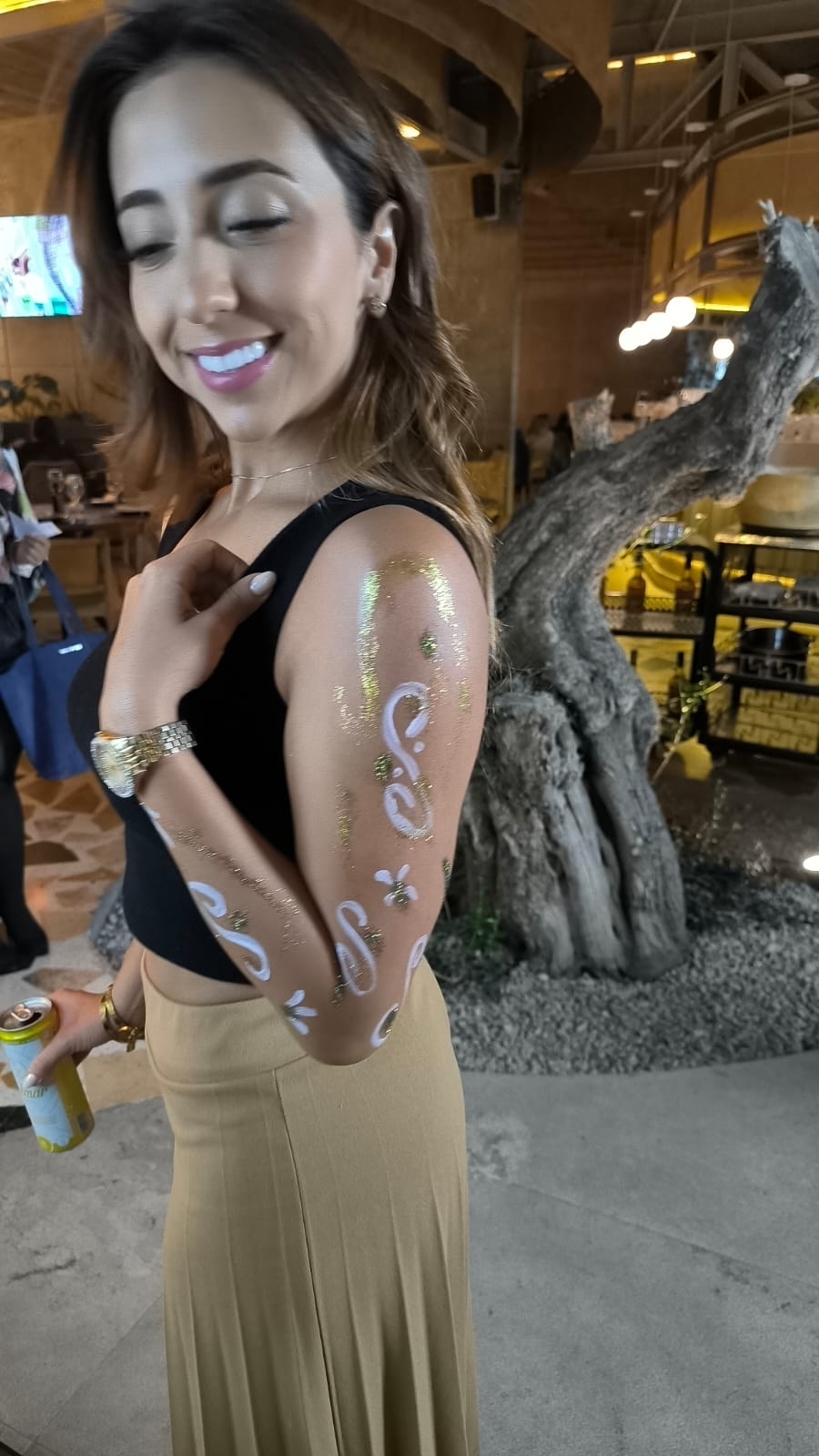 Moderno bar interior con plantas decorativas, gran ventana y arte natural en la pared.