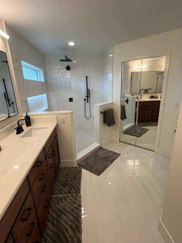 This stunning primary bathroom features a spacious tiled shower, designed with ample room for two, offering both luxury and comfort. 