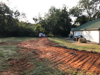 The customer was having problems with water running off the hill behind his building, the solution was to build a slope back to the hill and make a valley for the water to run down.