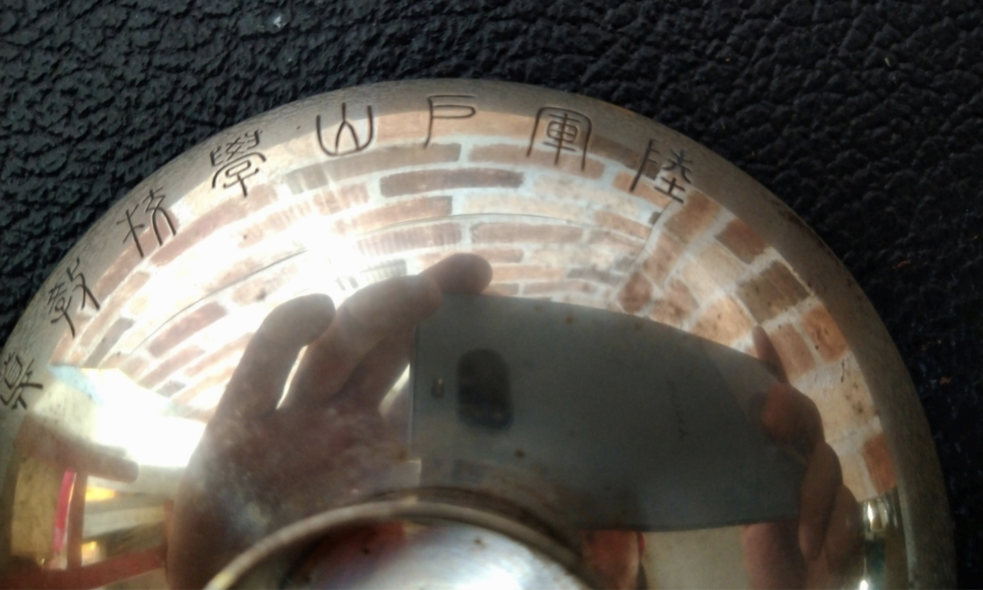 Close up of engraving - an historic sterling silver sake cup that was once presented to the 3rd Company, Instruction Battalion of the Toyama Military Academy pre-1945.  Around the outer rim is engraved 陸軍戸山学校教導大隊第三中隊記念