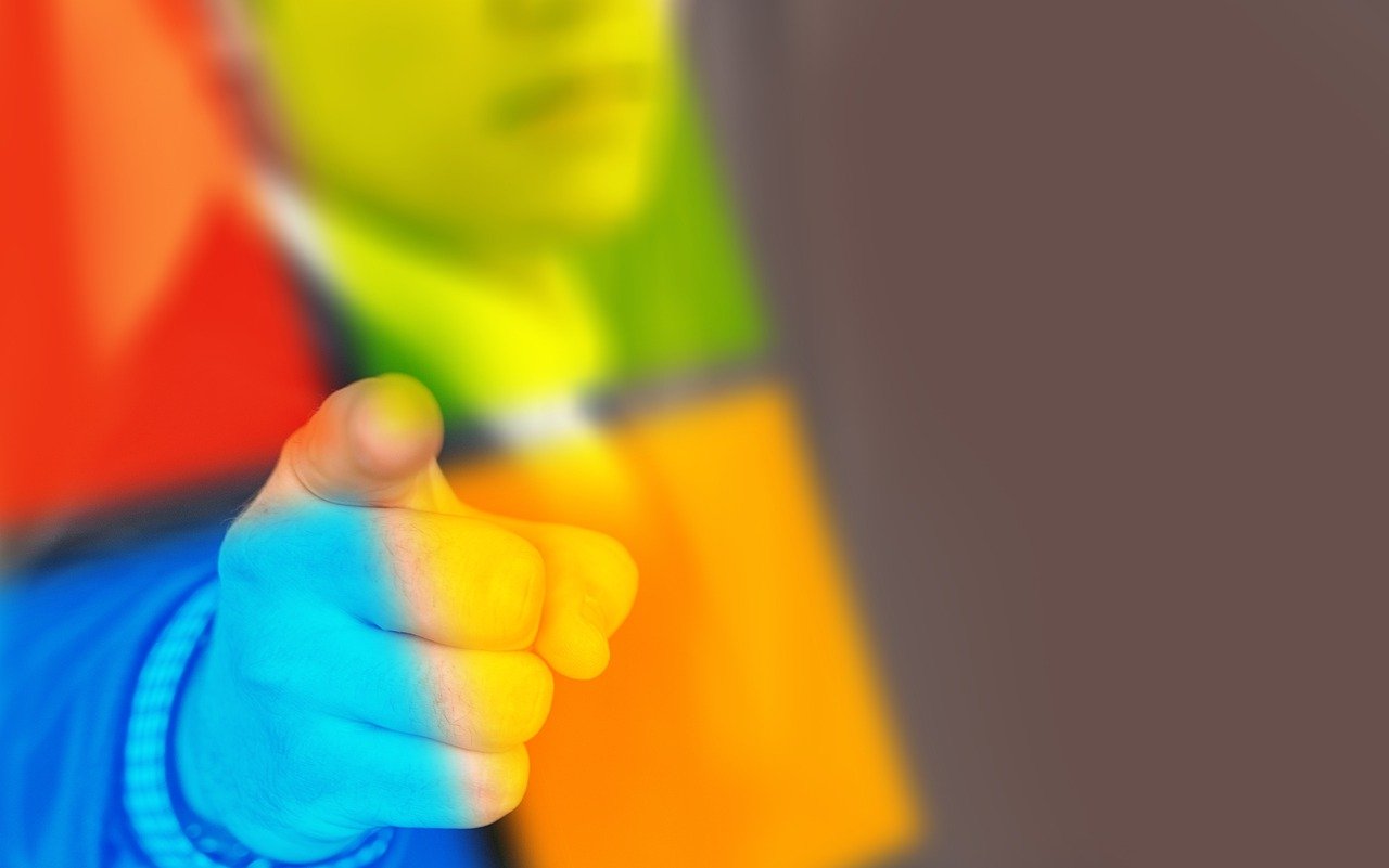 A man pointing his finger at a translucent Microsoft logo