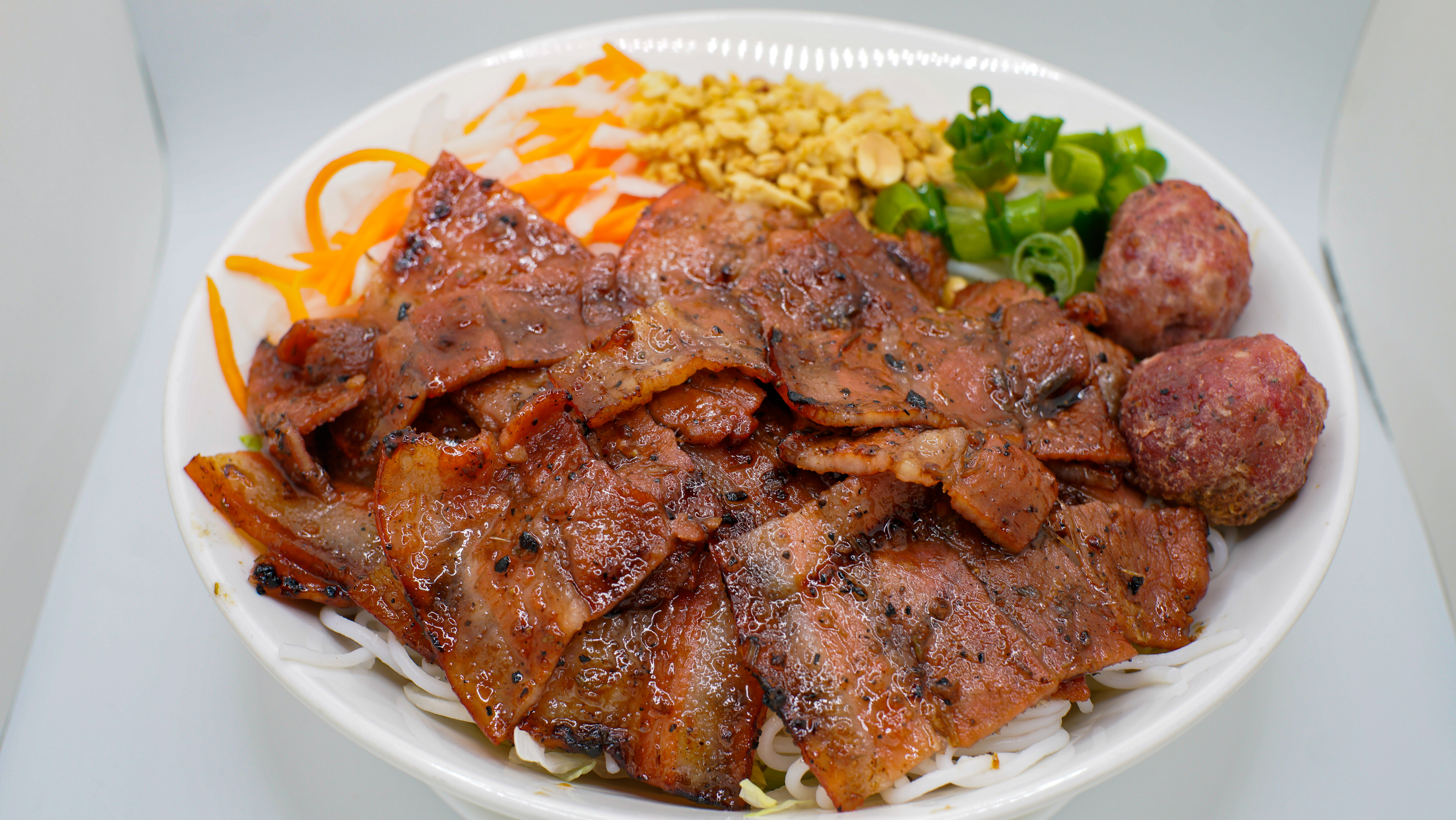 10B. BUN CHA HA NOI (G) (BOWL)
Hanoi Style w/ Ground Pork and
Grilled Thin Sliced Pork 
Served w/ Sweet and Sour 
Fish Sauce