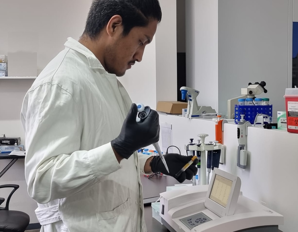 mujer con camisa blanca de manga larga sujetando herramienta de metal plateada y negra