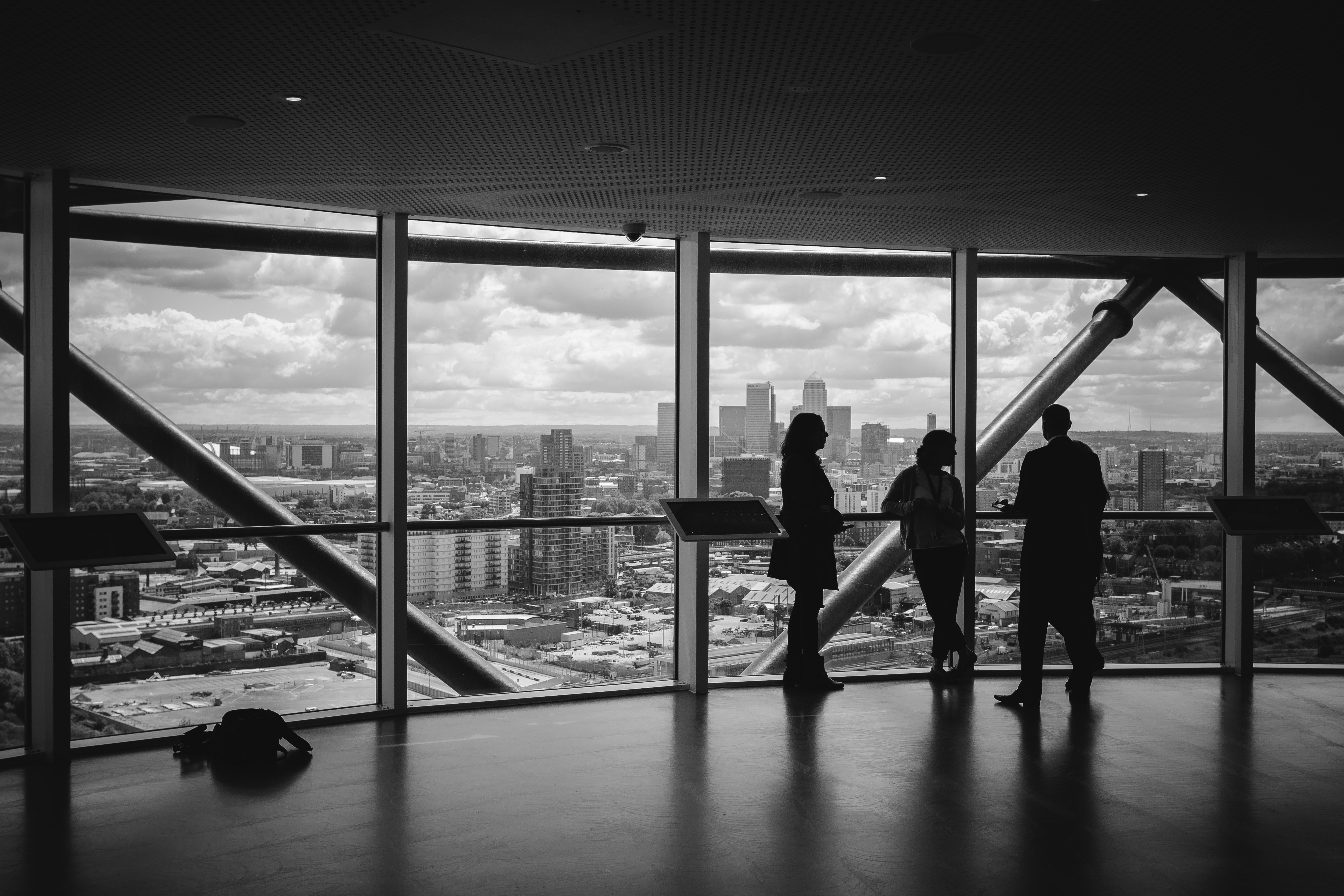 Black and white photo on people in a building overlooking a city
