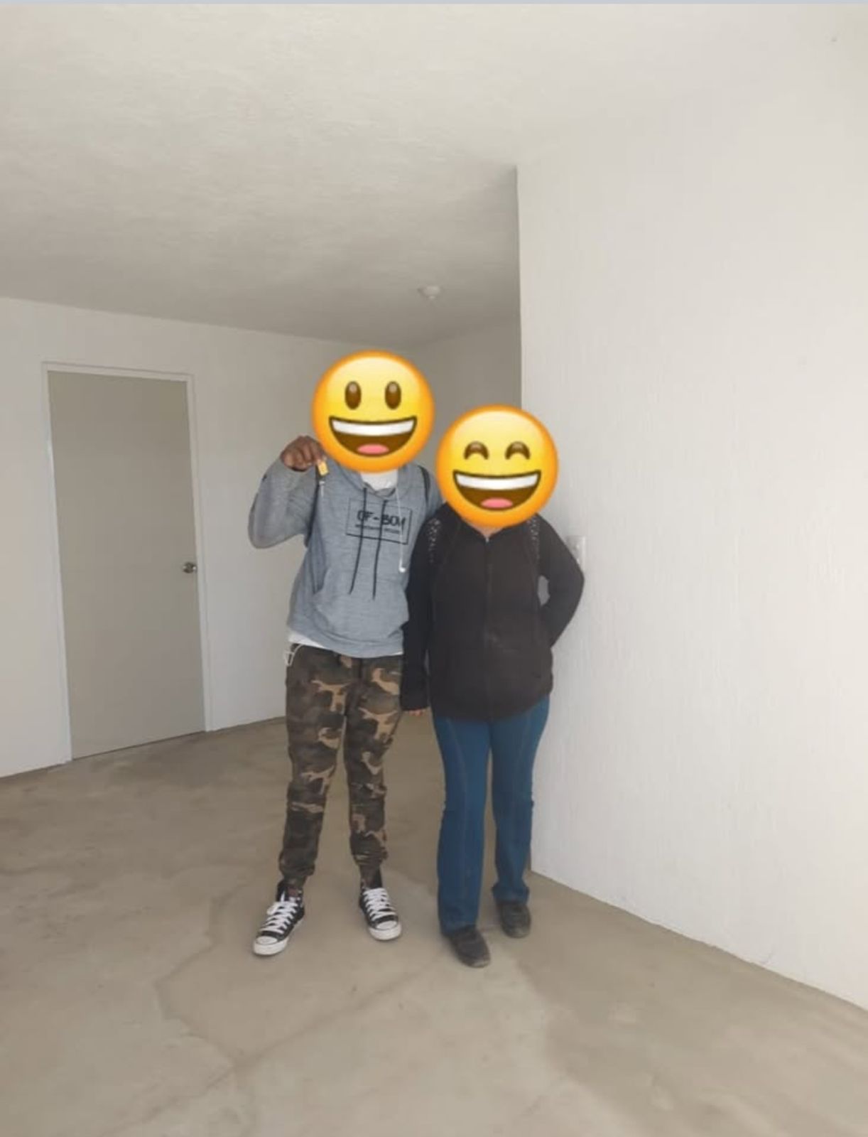 Sala de estar moderna con sofá blanco, plantas en macetas y gran ventana con vista a la ciudad.