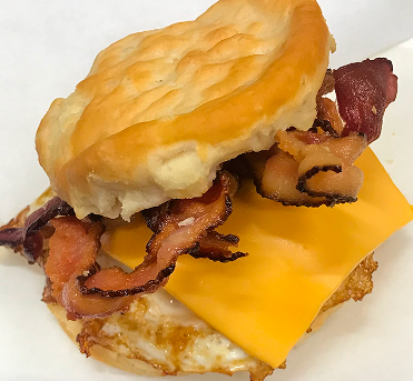 A biscuit with bacon and cheese on it