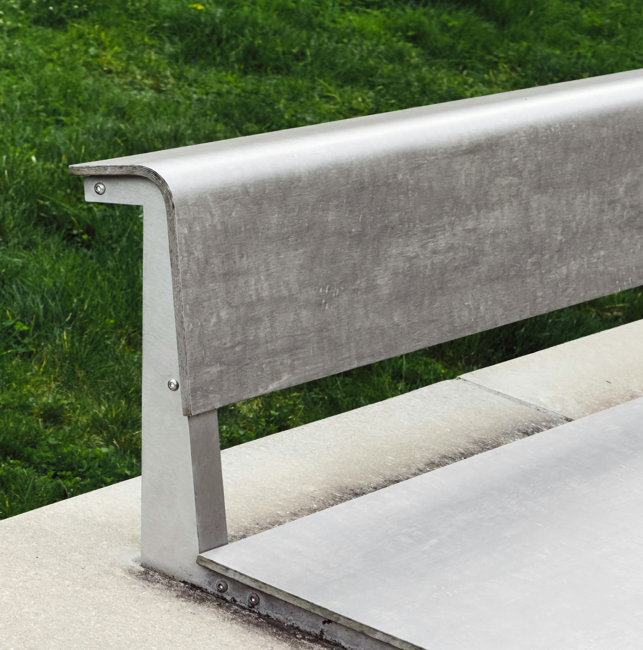 a metal bench sitting on top of a cement slab