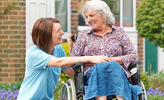 Carer With Senior Woman In Wheelchair