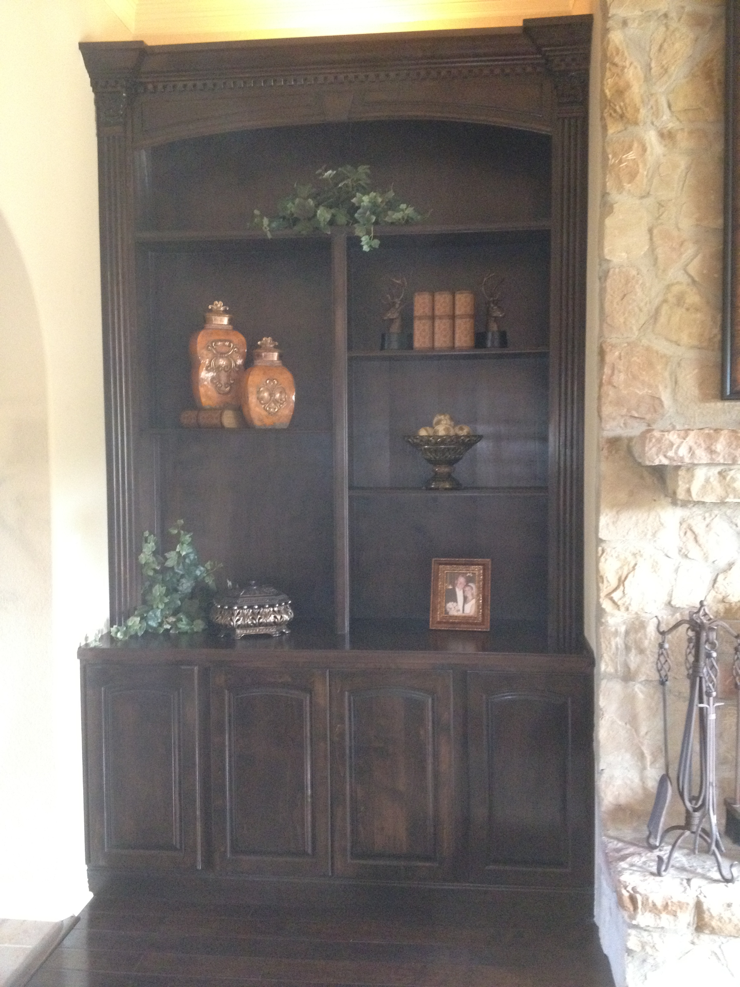 Bookshelf features arched raised paneled
 doors, adjustable shelves, columns, capitals,
 dentil crown molding, arch with keystone, high
 intensity lighting, and flourescent top lighting.