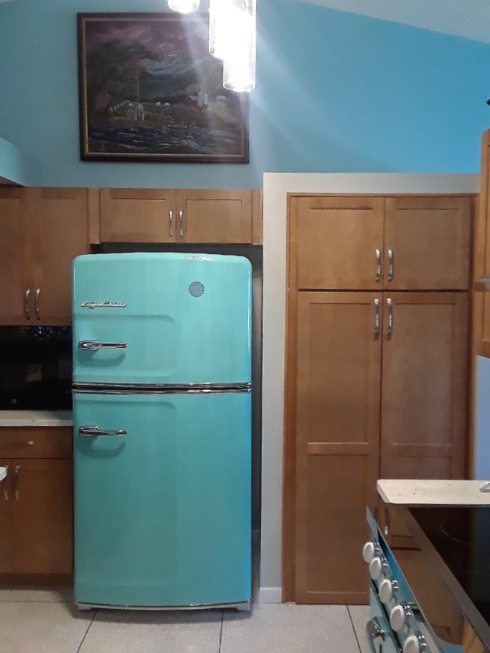 Shaker style Sahara-stained cabinetry with retro refrigerator in Turquoise. 