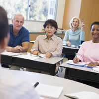 Mature Female Student Raising Hand In Class