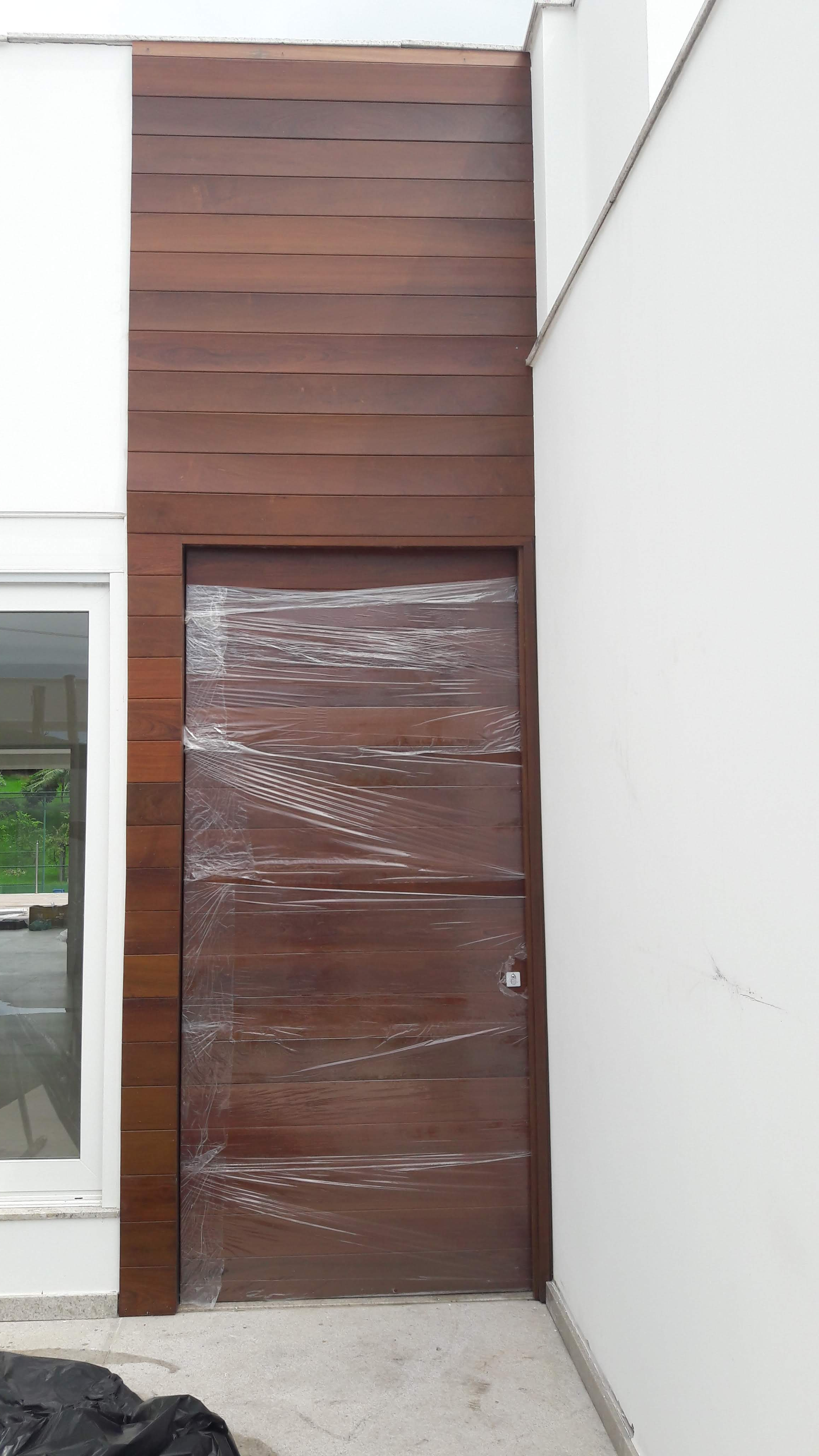 Porta 705 - Porta de madeira com  sistema de abertura pivotante, painel de madeira, envernizada.