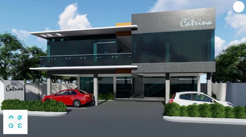 Edificio moderno de dos pisos con fachada de cristal, estacionamiento frontal y vegetación, cielo despejado.